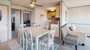 Un espacio habitable compacto con comedor, kitchenette y zona de estar.