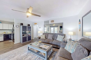 A living room with a sofa, coffee table, and a ceiling fan.