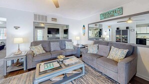 A living room with two grey sofas, a coffee table, and a ceiling fan. - Marathon North 103 (Ocean City)