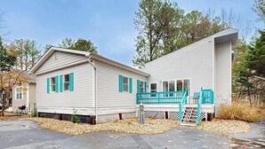 A two-story house with a porch and a garage. - Teal Haven (Ocean Pines)