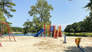 Ein Spielplatz mit Rutsche, Klettergerüsten und Schaukeln.