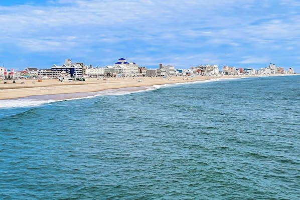 Een kuststadsgezicht met een strand, gebouwen en een heldere lucht.
