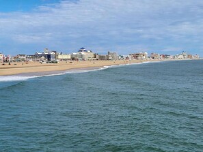 A coastal cityscape with a beach, buildings, and a clear sky. - Lovely condo with water view, pool, balcony, fast WiFi, & washer/dryer (Ocean City)