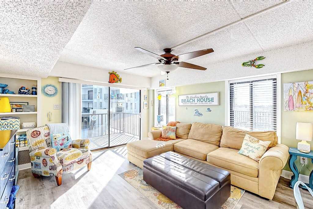 A living room with a sofa, ottoman, and a chair with a colorful pattern.