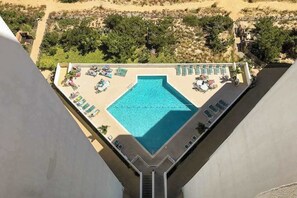 A rooftop pool with a clear view of the surrounding landscape, including trees and a sandy area. - Oceanfront condo with a furnished balcony, central AC, washer/dryer, & pool (Ocean City)