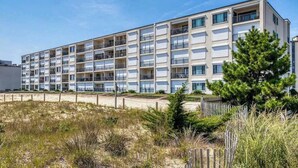 A multi-story hotel with balconies, located near a beach. - Breakaway East 107 (Ocean City)