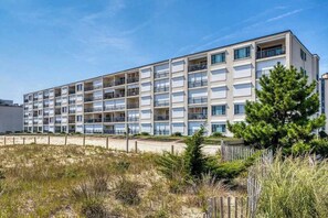 A multi-story hotel with balconies, located near a beach. - Breakaway East 107 (Ocean City)