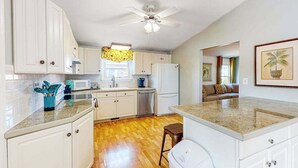 A kitchen with white cabinets, a microwave, a refrigerator, and a ceiling fan. - Bayside Keys 627 (Ocean City)