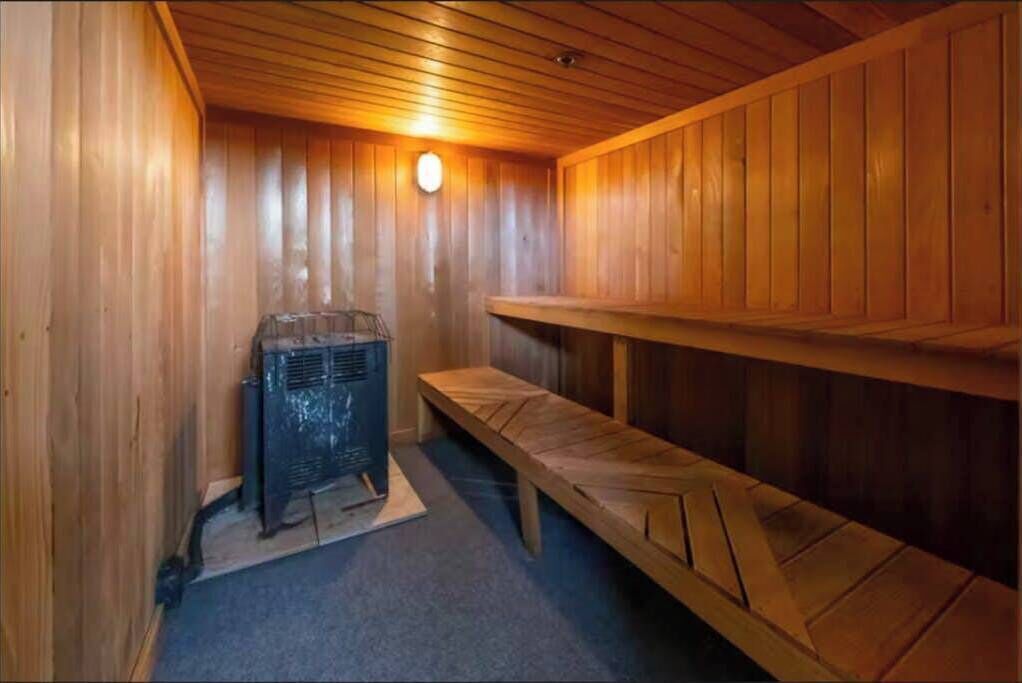 Una sauna con pareti in legno, una panca e uno scaldabagno.