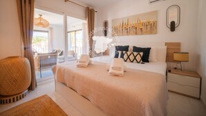 A bedroom with a bed, a nightstand, a lamp, a wall-mounted mirror, and a painting. - CostaBlancaDreams - Casa Kaiyo in Calpe (Calpe / Calp)