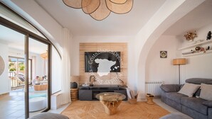 A modern living room with a sofa, a coffee table, a TV, and a view of an outdoor area. - CostaBlancaDreams - Casa Kaiyo in Calpe (Calpe / Calp)