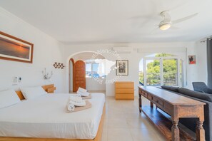 A modern hotel room with a large bed, a wooden bench, a sofa, and a view of the outdoors. - CostaBlancaDreams - Villa Mar y Monte in Calpe (Calpe / Calp)
