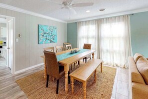 A dining area with a wooden table, chairs, and a bench. - Channel Buoy 120 on Canal (Ocean City)