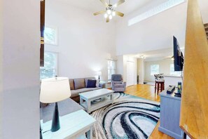 A spacious living room with a sofa, armchair, coffee table, and a TV stand. - 5 Whitecap (Ocean Pines)
