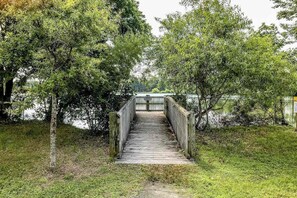 A wooden bridge leading to a dock over a body of water. - 5 Whitecap (Ocean Pines)