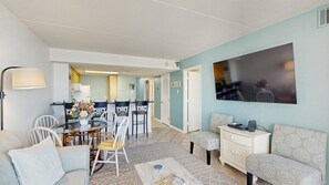 Ein Wohnzimmer mit einer Couch, einem Couchtisch und einem Essbereich mit Stühlen und einem Tisch.