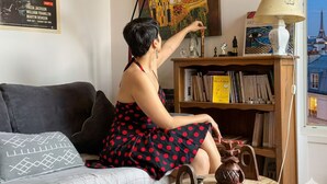 A room with a sofa, a bookshelf, a lamp, and a view of the Eiffel Tower. - celine 19  (Paris)