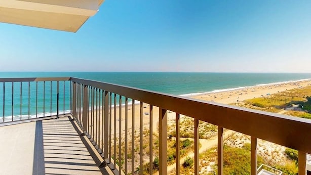 Ein Balkon mit Blick auf Strand und Meer.