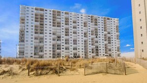 A multi-story hotel with a uniform facade, balconies, and a sandy beach in the foreground. - Plaza 811 (Ocean City)