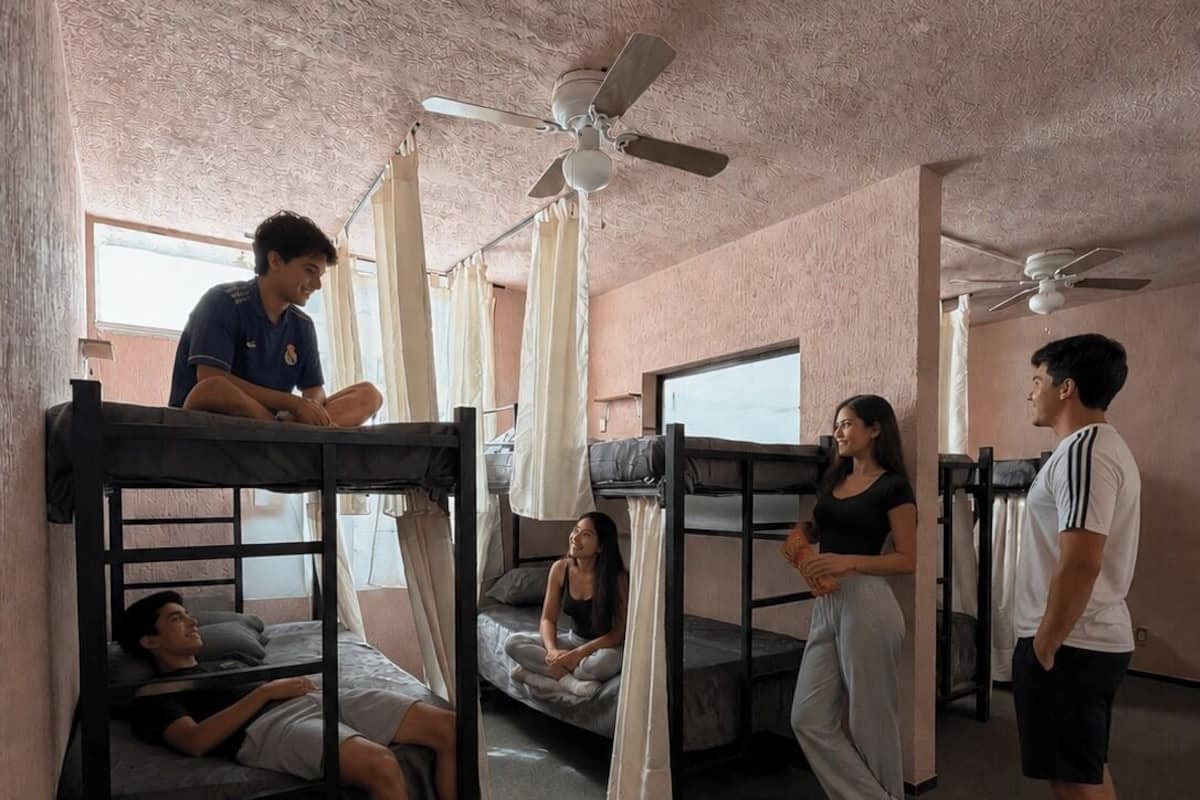 Un dormitorio con literas, ventiladores de techo y una ventana.