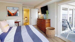 A hotel room with a bed, a dresser, a television, and a view of the outside. - Luxury waterfront condo w/water views from balcony, shared pool, AC & free WiFi (Ocean City)