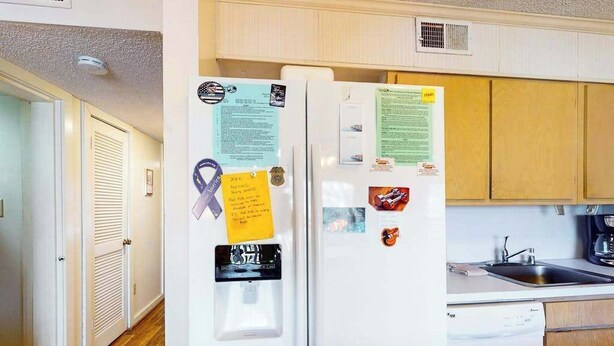 A kitchen with a refrigerator, a sink, and wooden cabinets. - Our Place At The Beach 202I (Ocean City)