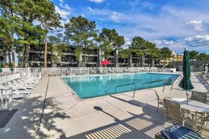 A swimming pool with lounge chairs and umbrellas, surrounded by trees and buildings. - Our Place At The Beach 202I (Ocean City)
