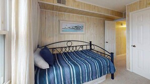 A bedroom with a bed, a painting on the wall, and a door. - Midtown Ocean City Condo short walk to beach, restaurants & shops (Ocean City)