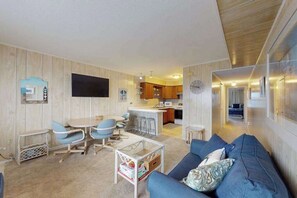 Un espacio habitable compacto con comedor, kitchenette y sofá.