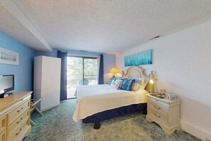 Ein Schlafzimmer mit Bett, Schminktisch, Fernseher und Fenster mit Blick.