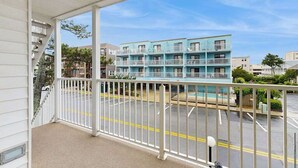 Un balcon donnant sur un immeuble à plusieurs étages, lui-même doté de balcons.