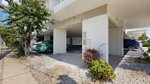 A parking garage entrance with a private property sign, a tree, and parked cars. - Astoria 302 (Ocean City)