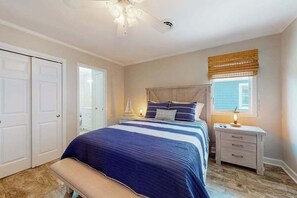 A bedroom with a bed, bedside tables, a bench, a ceiling fan, and a window with a blind. - Inviting home near beaches with fast WiFi, AC, full kitchen & W/D - dog-friendly (Ocean City)
