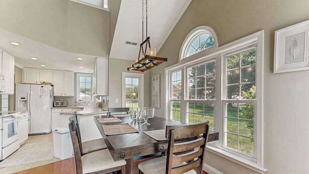 A kitchen with white cabinets, a wooden island, and a large window. - 4BR Coastal Getaway - Golf, Pool & OC Beach access in Berlin, MD (Berlin)