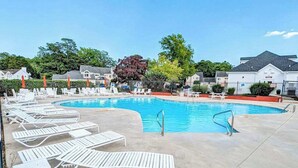 A swimming pool with lounge chairs, a concrete deck, and houses in the background. - 4BR Coastal Getaway - Golf, Pool & OC Beach access in Berlin, MD (Berlin)
