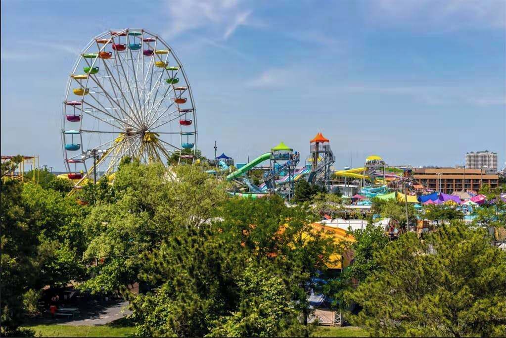 Ein Riesenrad, Wasserrutschen und eine Achterbahn in einem Freizeitpark.