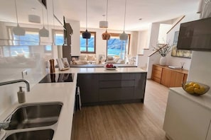 A modern kitchen with a central island, stainless steel sink, and pendant lighting. - Palazzo Pognana with Infinity Pool and Lake Views (Pognana Lario)