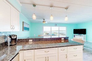 A kitchen with a granite countertop, white cabinets, a ceiling fan, and pendant lights. - Assateague House 306 | Condo in Ocean City (Ocean City)