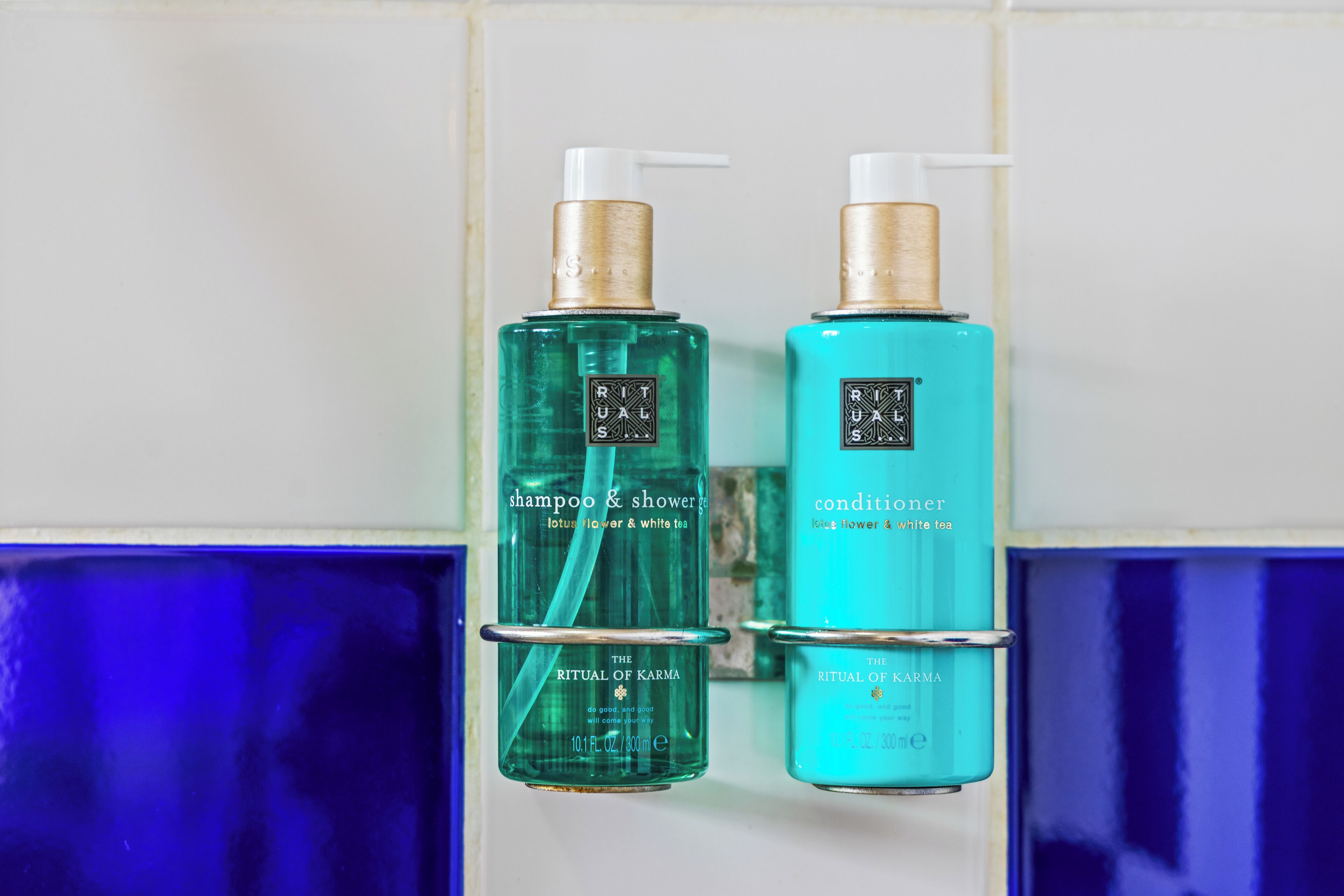 Dos botellas de champú y acondicionador Ritual de Karma.