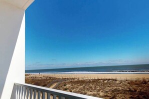 A beach view from a balcony with a clear sky. - Oceanfront, 2nd-floor condo with gorgeous view, balcony, pool & great location (Ocean City)