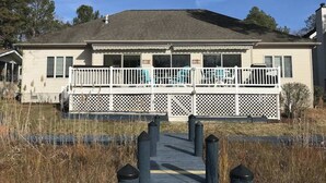 A two-story house with a front porch, a covered deck, and a pathway leading to the entrance. - Turtle Shores-22 Boston (Ocean Pines)