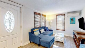 Ein Wohnzimmer mit einem blauen Sofa, einem Couchtisch und einem Fernsehschrank.