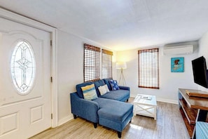A living room with a blue sofa, a coffee table, and a TV stand.