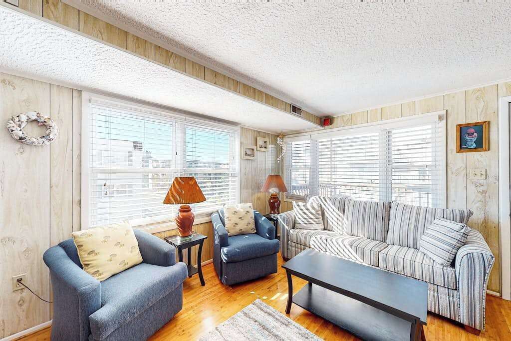 A living room with a blue sofa, striped couch, and a coffee table.