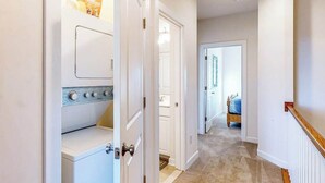 A hallway with a laundry room, a bedroom, and a door leading to another room. - Seaside Village Bowline 13007 -2 (West Ocean City)