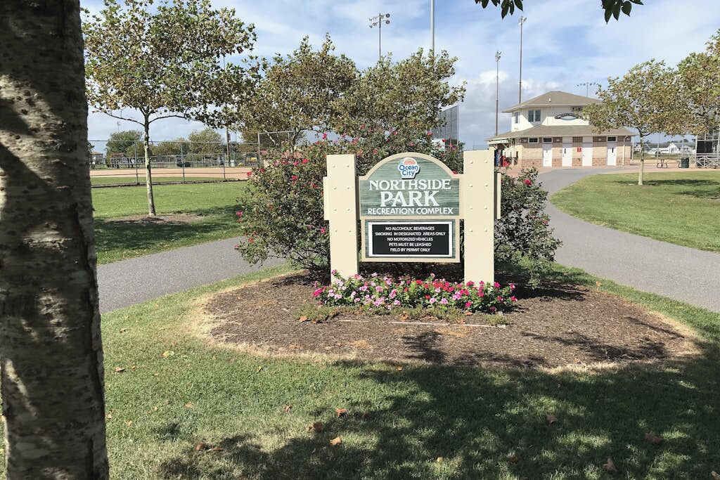 Segnale per il complesso ricreativo Northside Park, con un percorso ben definito che vi conduce, circondato da erba e alberi.