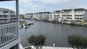 A marina with boats docked, a waterfront view, and a row of multi-story buildings with balconies. - Waterfront escape with two pools, outdoor shower, balcony, WiFi & central AC (Ocean City)