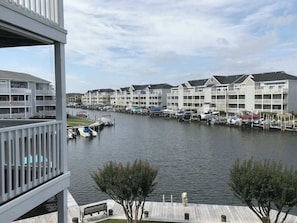 Ein Hafen mit vertäuten Booten, Blick auf das Wasser und eine Reihe mehrstöckiger Gebäude mit Balkonen.