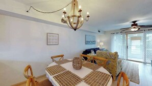 Ein Essbereich mit einer Chandelüster, einem runden Tisch und Stühlen.