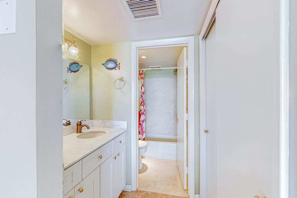 Une salle de bain avec deux lavabos, des toilettes et une douche.